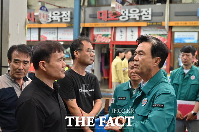 17일 김태흠 충남도지사(오른쪽)가 폭우로 침수 피해를 입은 당진 어시장을 찾아 상인들을 위로하고 있다. /충남도