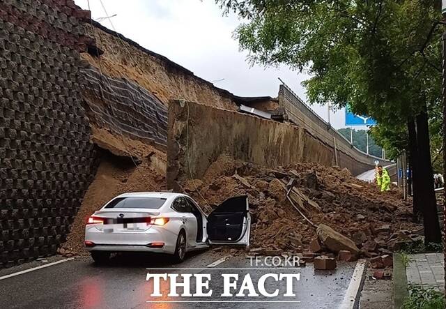 수도권 등 중부지역에 호우주의보가 발효된 지난 16일 경기 오산시 가장교차로 옹벽이 도로로 무너져 차량을 덮치는 사고가 발생해 소방 당국이 대응 1단계를 발령, 구조작업을 벌이고 있다. /뉴시스
