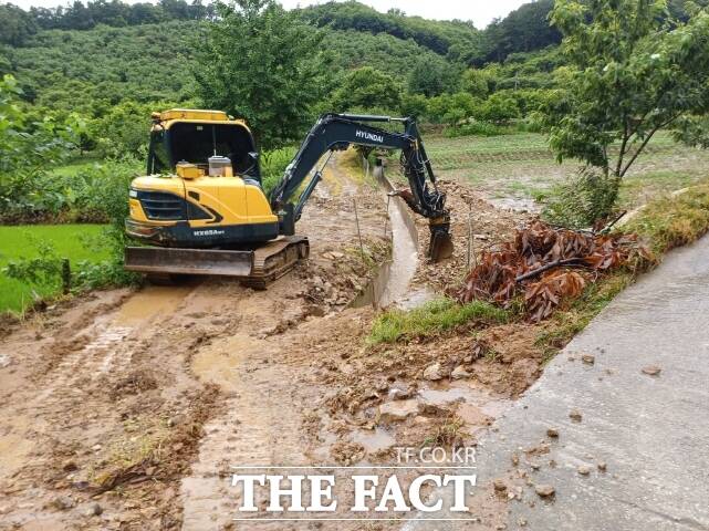 부여군이 17일 집중호우로 인한 토사유출 등 사고로 도로가 유실되자 긴급복구잡업을 하고 있다. /부여군