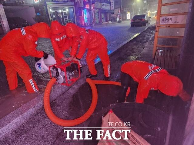 서산시 읍대동 서부상가 하수관로에서 서산소방서 대원들이 빗물을 퍼내며 상가 침수를 막고 있다. /서산시