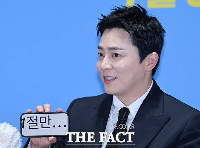 옆으로 1절만...이라고 적은 스마트폰을 들어보이는 조정적 배우