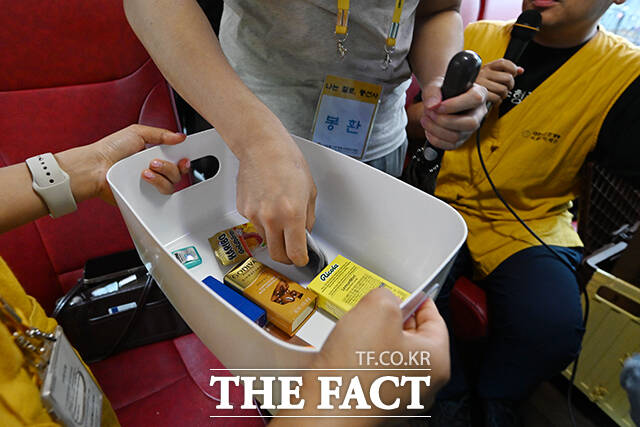 남성 참가자들이 소지품을 제출하고 있다. 이후 여성 참가자들의 무작위 뽑기를 통해 버스 안에서의 자리가 결정된다.