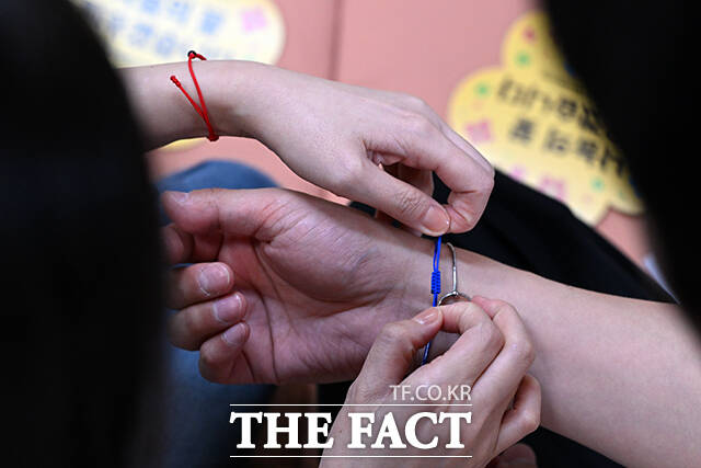 청실과 홍실 단주를 받아 서로의 손목에 차고 있다.