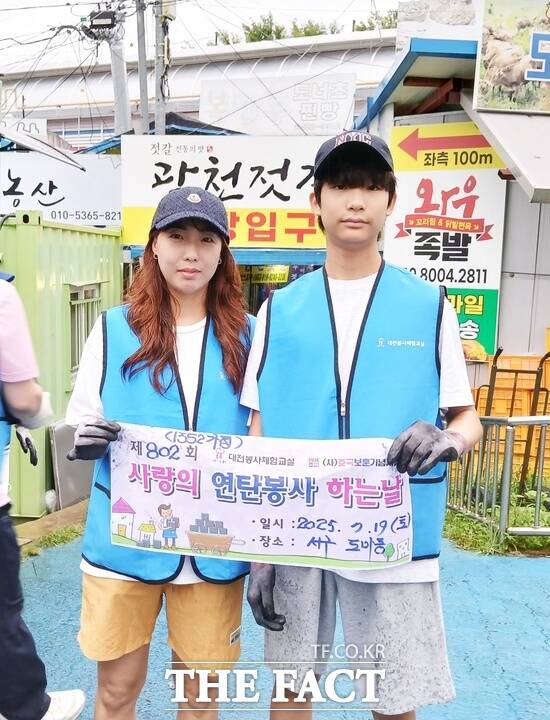 대전중학교 2학년에 재학 중인 강기태(사진 오른쪽) 학생이 장대비가 쏟아지는 19일 새벽 친구들의 권유로 엄마인 성혜주 씨와 함께 대전봉사체험교실이 진행하는 연탄나눔 봉사활동에서 첫 봉사를 시작했다./대전봉사체험교실