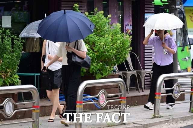 [더팩트ㅣ남윤호 기자] 13일 오후 서울 종로구 창성동 거리에서 시민들이 우산을 쓴 채 걸음을 옮기고 있다.