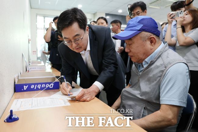 지난 21일 오후 김동연 경기도지사가 원천동 행정복지센터를 방문해 어르신의 신청서류 작성을 돕고 있다. /경기도