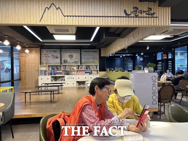 서울시 디지털안내사가 도봉구 마을가족카페 너른마루에서 스마트폰 사용법을 교육하는 모습. /더팩트 DB