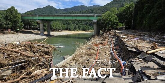 지난 16~20일 경기 북부지역을 강타한 극한호우로 경기 가평군의 한 하천변 도로가 유실되고 하천 중간에 산에서 떠밀려온 나뭇가지들이 수북이 쌓여 있는 모습./가평군