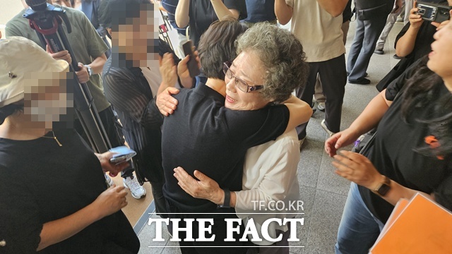 61년 전 자신을 성폭행하려던 남성의 혀를 깨물었다가 되려 중상해 혐의로 기소돼 유죄 판결을 받았던 최말자(78) 씨가 23일 부산지법에서 열린 재심 첫 공판을 마치고 법정을 나서며 여성단체와 포옹하고 있다. /박호경 기자