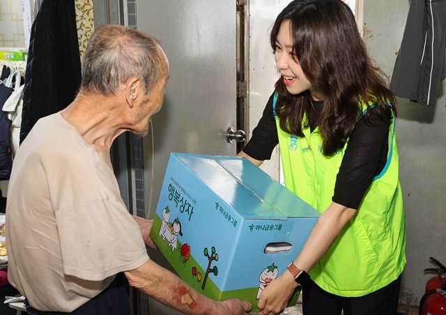 하나금융그룹은 지난 21일 오후 기록적인 폭염으로 어려움을 겪고 있는 지역사회 취약계층을 위해 여름철 필수품이 담긴 시원한 여름나기 행복상자 1111개를 전달했다. 이날 행사에 참석한 하나금융 직원이 창신동 인근 쪽방촌에 찾아가 독거 어르신에게 행복상자를 전달하고 있다. /하나금융
