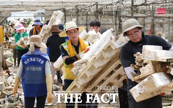 박희조 동구청장을 비롯한 자원봉사자들이 예산군 수해복구 현장에서 봉사활동을 하고 있다./대전 동구