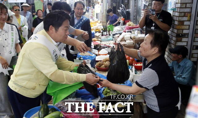 오세현 아산시장이 온양온천시장에서 민생회복 소비 촉진 캠페인 활동 중 물건을 구매하고 있다. /아산시