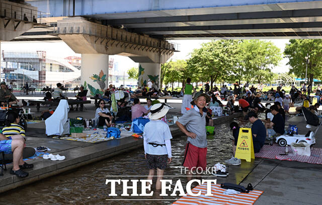 24일 수도권을 포함한 전국 대부분 지역에 폭염특보가 발효되며 찜통더위가 이어지겠다. 사진은 서울 여의도 한강공원 물빛광장을 찾은 시민들이 물가에 모여 더위를 식히고 있는 모습./이새롬 기자