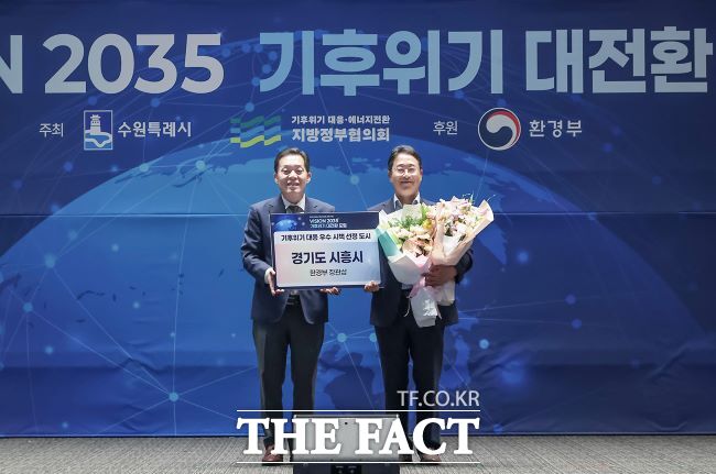 시흥시가 기후위기 대응 우수 시책으로 선정돼 이재준 수원시장(왼쪽)으로부터 환경부 장관상을 전달받고 있다. /시흥시