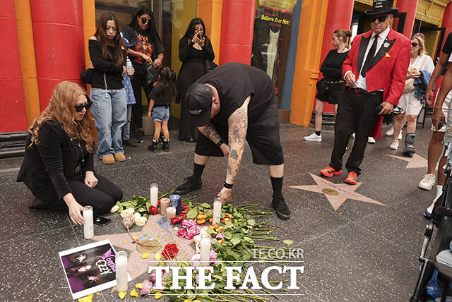 22일(현지시간) 미 캘리포니아주 로스앤젤레스 할리우드 명예의 거리에서 오지 오즈번의 팬들이 고인의 별 판에 헌화하고 있다. /로스앤젤레스=AP.뉴시스
