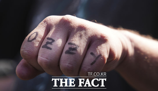 오지 오스본의 팬이 할리우드 명예의 거리에서 오지 오스본의 이름을 손가락에 새기고 있다. /로스앤젤레스=AP.뉴시스