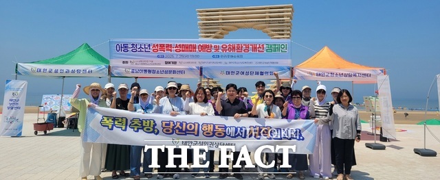 태안군이 지난 25일 만리포 해수욕장에서 진행한 아동·청소년 유해환경 개선 및 성폭력·성매매 근절 캠페인 중 기념촬영을 하고 있다. /태안군