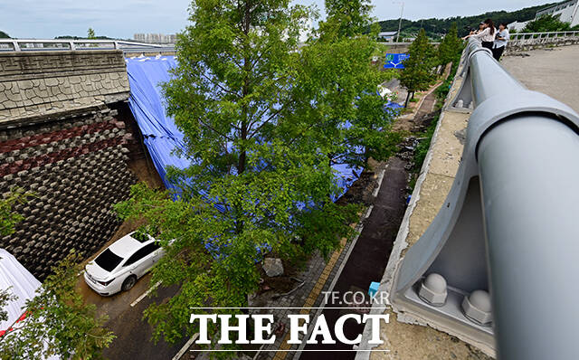 16일 저녁 시간당 41mm의 강한 비로 옹벽을 지지하던 토사가 침하돼 차량을 덮치는 사고가 발생한 가운데 18일 오전 경기 오산시 가장동 가장교차로 인근 사고 현장에는 벽돌과 토사가 차량을 뒤덮은 모습이 그대로 남아 있다. /임영무 기자