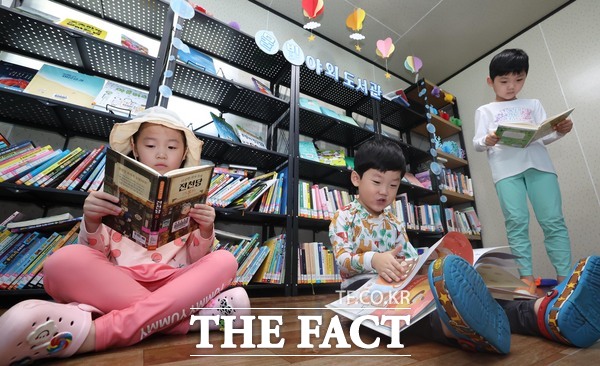 용수골 어린이물놀이장에 마련된 물빛 야외도서관에서 아이들이 독서를 하고 있는 모습 /대전 동구