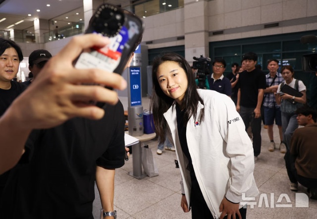 7월 28일 귀국한 안세영이 인천국제공항에서 팬과 기념사진을 찍고 있다. 무릎부상으로 슈퍼 1000 슬램을 포기했지만 밝은 표정이었다. / 뉴시스