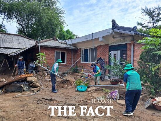 지난 20일 내린 집중 호우로 인해 큰 피해를 입은 경기 포천시의 한 주택을 찾은 자원봉사자들이 잔해물을 정리하고 있다./포천시