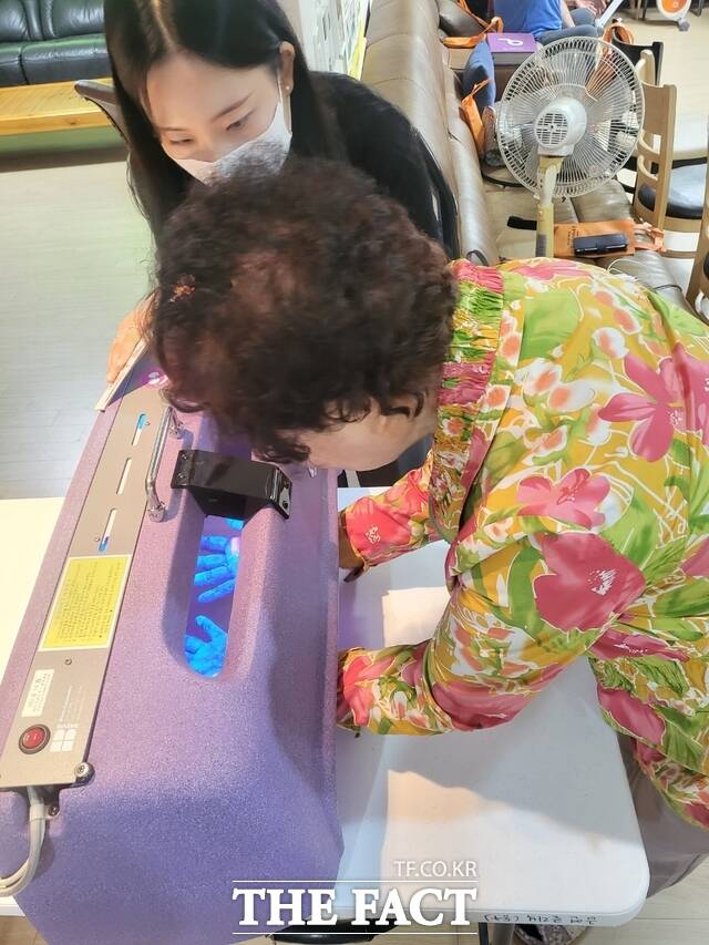 광주 동구가 찾아가는 결핵검진을 실시한 가운데 한 어르신이 글리터버그(손오염도 측정기) 체험을 하고 있다. /광주 동구