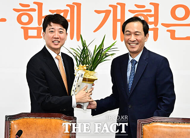 이준석 개혁신당 대표(왼쪽)가 4일 오후 서울 여의도 국회에서 우상호 대통령실 정무수석을 접견하며 이재명 대통령이 보낸 축하 난을 선물 받고 있다. /국회=배정한 기자