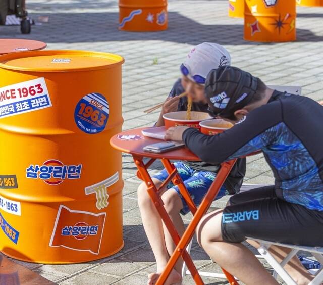 지난달부터 서울 여의도 한강수영장에서 운영 중인 삼양식품 브랜드 부스를 찾는 시민들이 늘고 있다. 사진은 수영 후 삼양라면을 먹는 어린이들 모습 /삼양식품