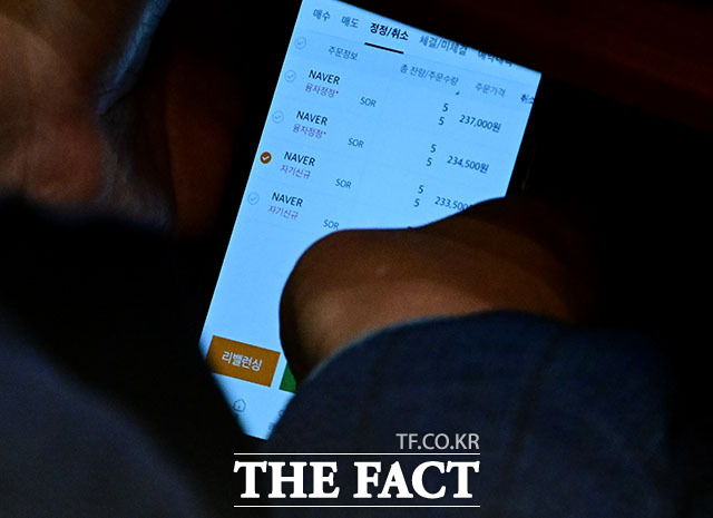 국회 법제사법위원회 위원장을 맡고 있는 이춘석 더불어민주당 의원이 4일 서울 여의도 국회에서 열린 본회의에서 타인 명의로 개설된 주식 계좌를 확인하고 있다. 이 의원의 휴대전화 속 주식 계좌의 주인은 차ㅇㅇ으로 이 의원을 국회 사무총장때부터 보좌해온 인물이다. 현재 이춘석 의원실의 보좌관으로 일하고 있다. /국회=남윤호 기자