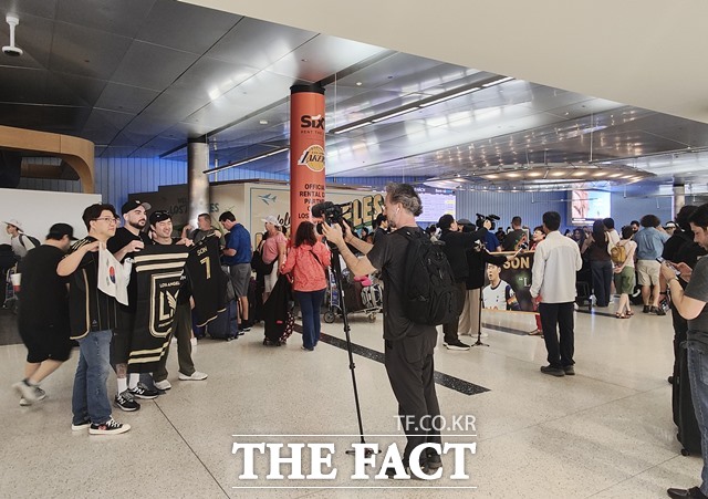 5일(현지 시간) LA 공항 톰 브래들리 입국장 로비에서 손흥민을 기다리던 한인팬들이 LAFC의 단기와 태극기 등을 펼쳐들고 기념촬영을 하고 있다./LA=미주헤럴드경제 제공