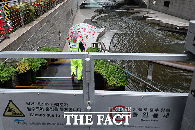 전국 대부분 지역에 많은 비가 내리고 있는 6일 오후 서울 종로구 청계천 산책로를 관계자가 통제하고 있다. /남용희 기자