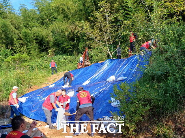 부여로터리클럽이 2일 충화면 수해 주택 인근에서 대량의 토사를 굴착기 등 장비를 동원해 신속히 제거하고 있다. /부여군