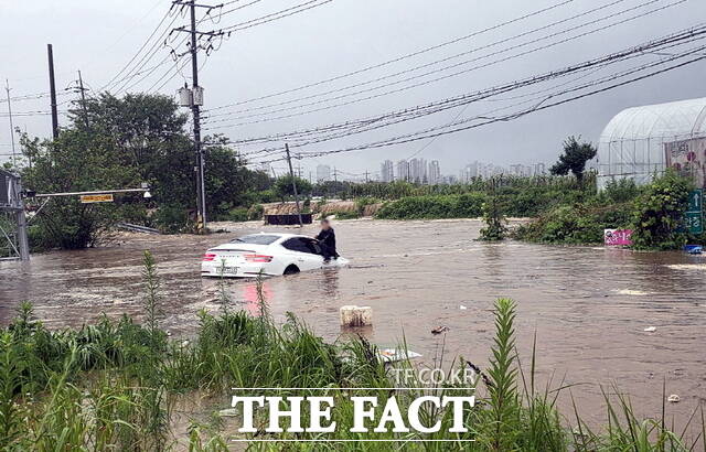 17일 곡교지하차도에서 급격히 불어난 물에 잠긴 승용차 보닛에 올라가 구조를 요청하는 운전자 모습./아산시
