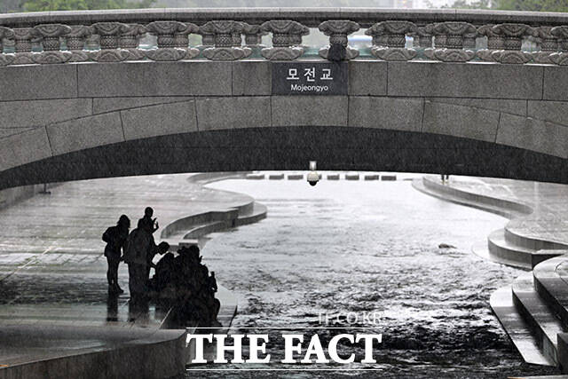 모전교 아래 비를 피하는 시민들.