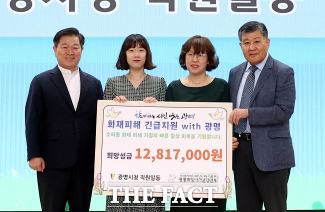 박승원 광명시장(왼쪽)이 시 공직자들을 대표해 소하동 아파트 화재 피해 주민 지원 성금을 전달하고 있다./광명시