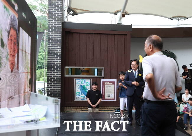 김동연 경기도지사(오른쪽 두 번째)가 9일 광주 나눔의 집에서 열린 기림의 날 기념식에서 인공지능으로 복원된 고 김순덕 할머니(왼쪽 화면)와 대화하고 있다./경기도