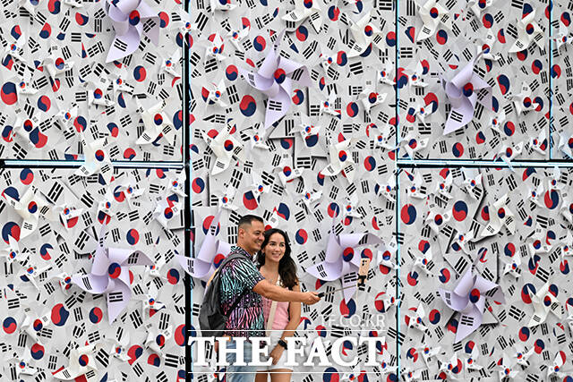 관광객들이 태극기 언덕 앞에서 기념 촬영을 하고 있다.