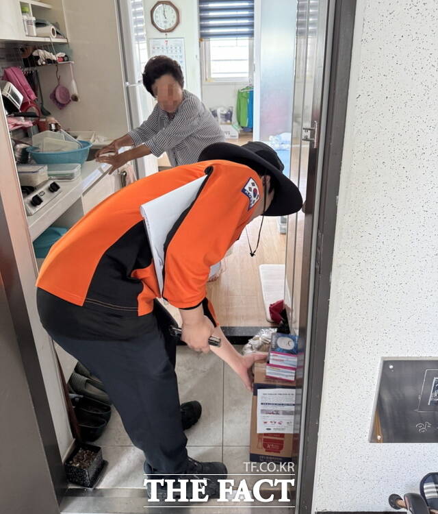소방관이 단독경보형 감지기와 소화기를 배부하고 있다./천안동남소방서