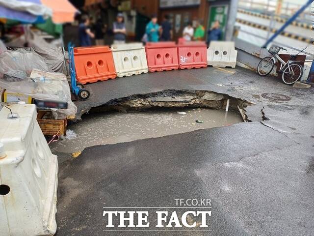 12일 오전 부산 사상구 새벽시장 앞 도로에 대형 땅꺼짐이 발생해 통행이 차단되어 있다. /부산경찰청