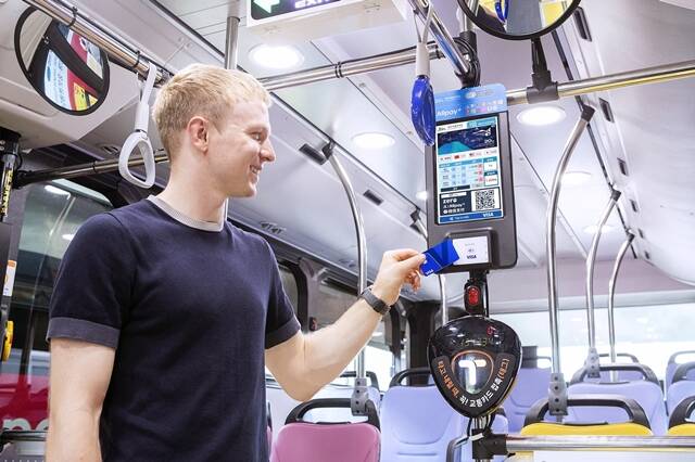 제주를 방문한 외국인 관광객이 시내버스에서 비자의 개방형 교통결제 시스템(Open-loop Transit)이 적용된 단말기에 비자카드를 태그해 승차하고 있다. /비자