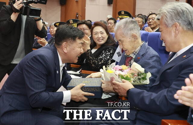 15일 오전 전북도청 공연장에서 열린 제80주년 8·15 광복절 경축식에 참석한 호남지역 유일 생존 애국지사인 이석규 선생에게 김관영 도지사(왼쪽)가 꽃다발을 전달하고 있다. /전북도