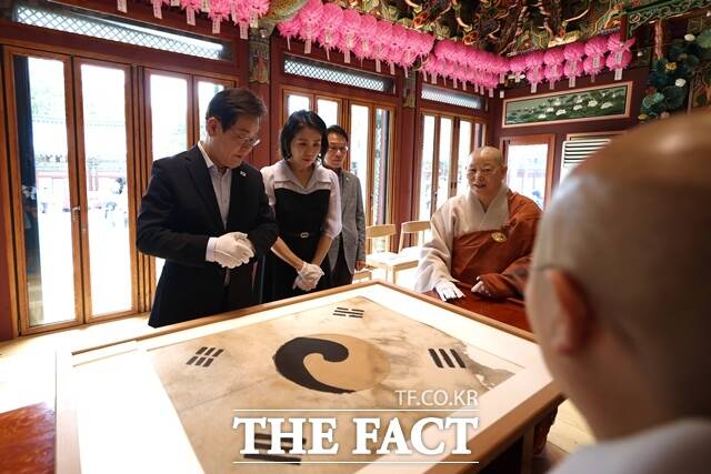 이재명 대통령과 영부인 김혜경 여사가 17일 오후 서울 은평구 진관사를 찾아 진관사 태극기를 살펴보고 있다. /대통령실