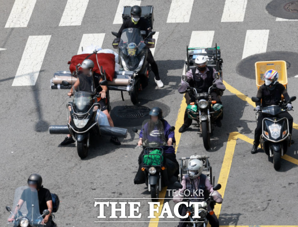 사진은 배달업 종사자들이 신호를 기다리는 모습. /뉴시스