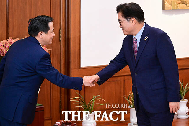 다이빙 대사 맞아 인사하는 우원식 국회의장(오른쪽).