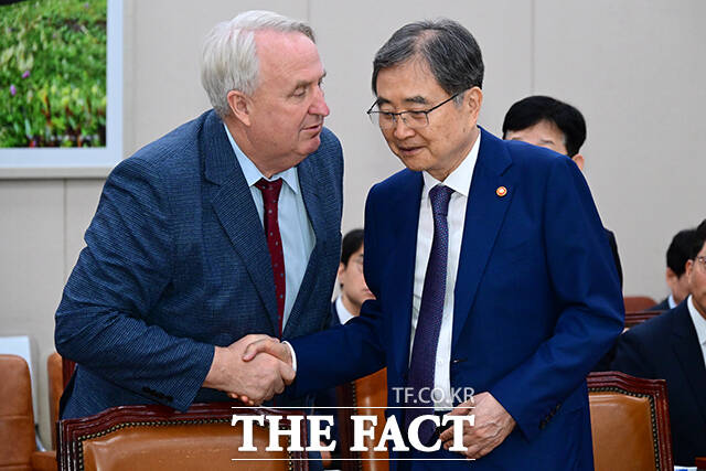 외교통일위원회 전체회의를 앞두고 인사하는 인요한 국민의힘 의원(왼쪽)과 조현 외교부 장관.