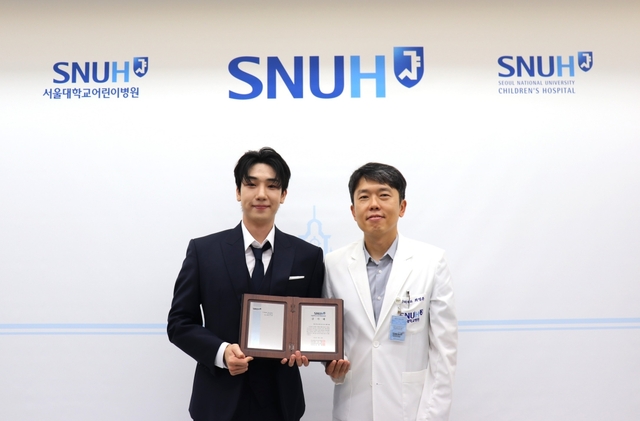 가수 최수호(왼쪽)가 공식 팬클럽 수방사(수호 방위 사령부)와 함께 서울대학교어린이병원에 기부금 1949만 2018원을 전달했다. /포고엔터