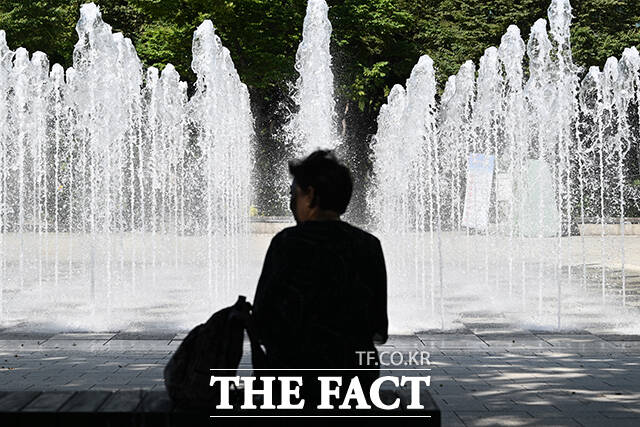 바닥 분수 앞에서 더위 식히는 시민들.