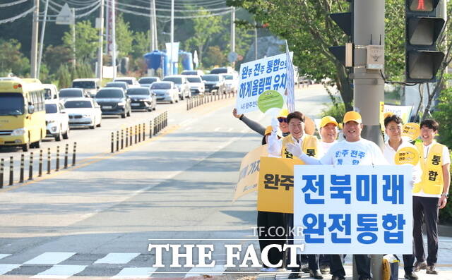 22일 우범기 전북 전주시장이 전주시 완산구 효자동3가 서전주아울렛 삼거리 일대에서 완주·전주 상생발전네트워크 회원들과 함께 출근길 통합 캠페인을 벌이고 있다. /전주시