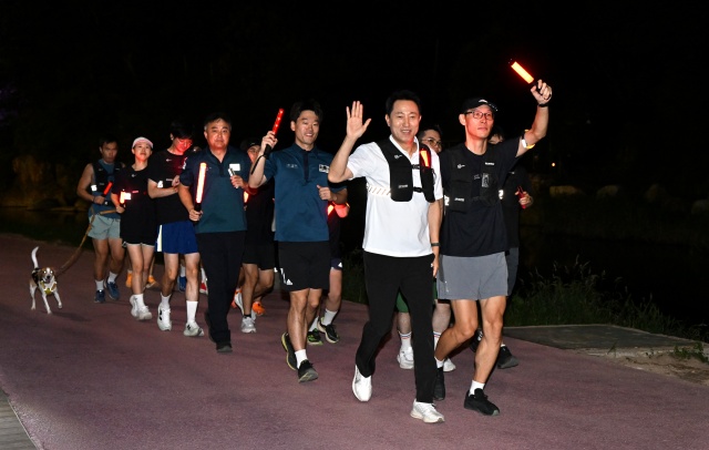 오세훈 서울시장이 21일, 서울 러닝 순찰대와 홍제천 일대 순찰 중 시민에게 손을 흔들며 인사하고 있다. /서울시