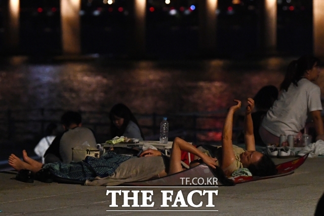 118년 기상 관측 사상 최장 열대야가 27일째 계속된 가운데 17일 오후 서울 영등포구 여의도 물빛광장에서 시민들이 더위를 식히고 있다. /서예원 기자